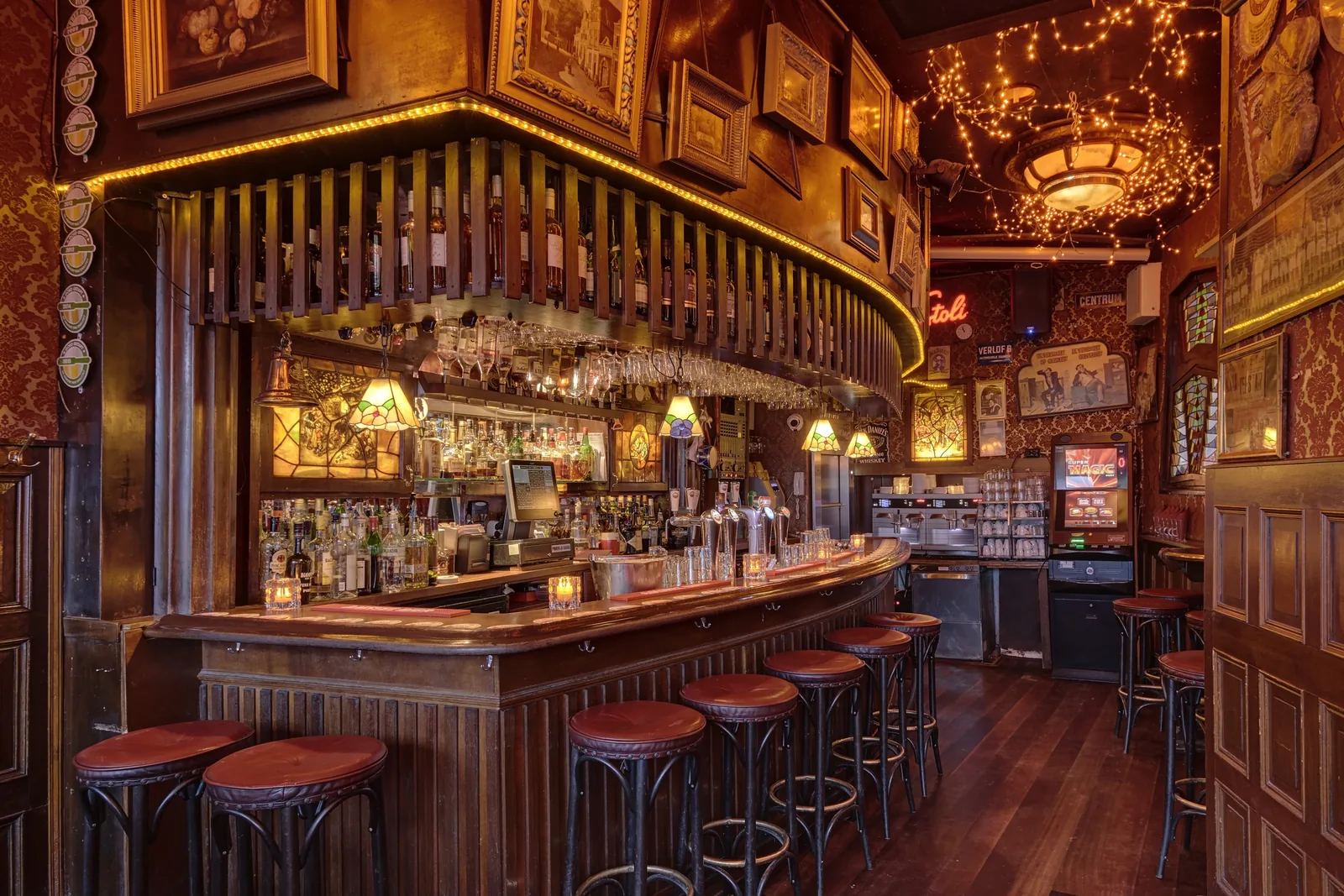 De ronde bruine bar met krukken en glazen aan het rek